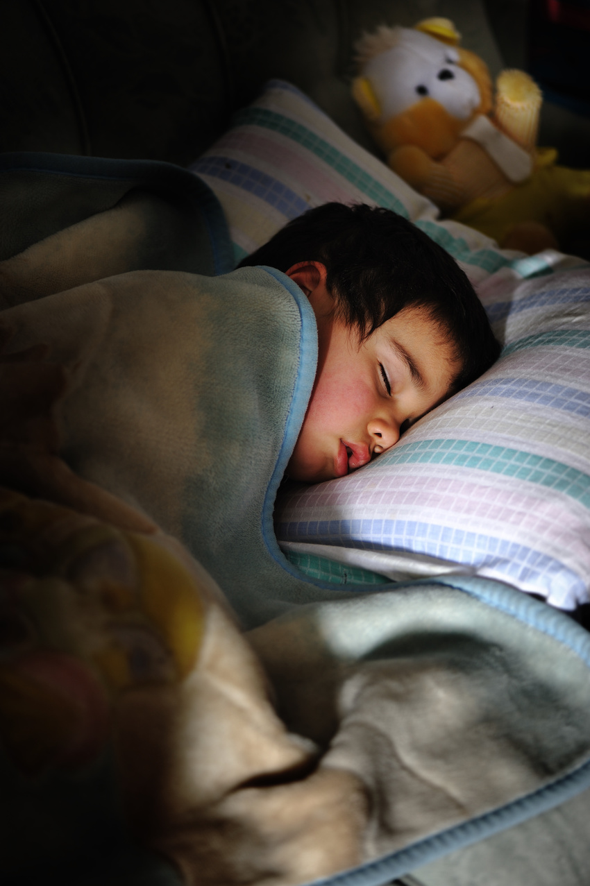 Kid Sleeping in Dark Room with Teddy Bear